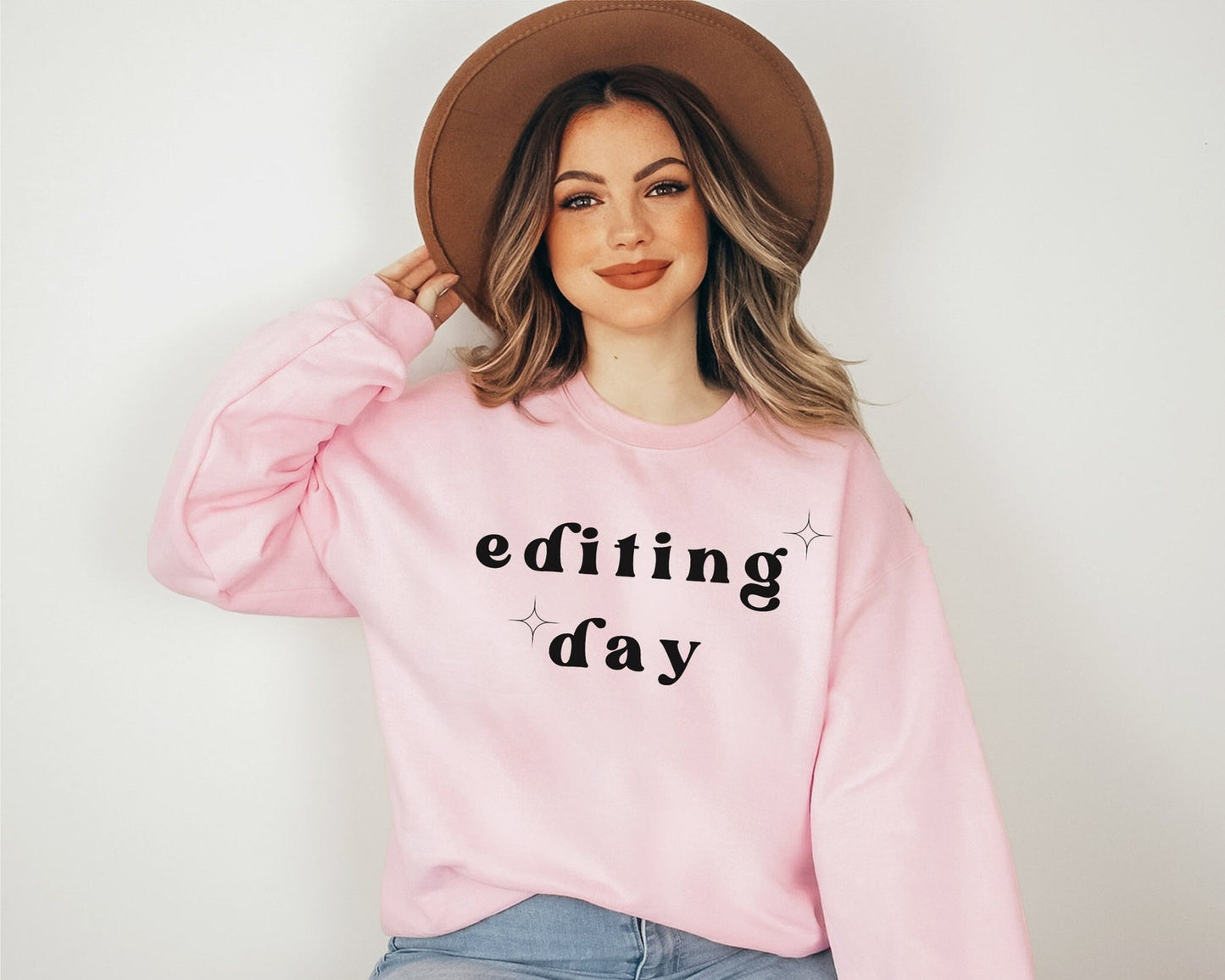 light pink "editing day" sweatshirt with retro text